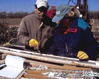 Picture of USGS scientists examining a core from a bore hole of a well. Approximately one-sixth of the United States population, or 41 million people, relied on the glacial aquifer system for drinking water in 2005. Photographer: Kelly Warner, USGS
